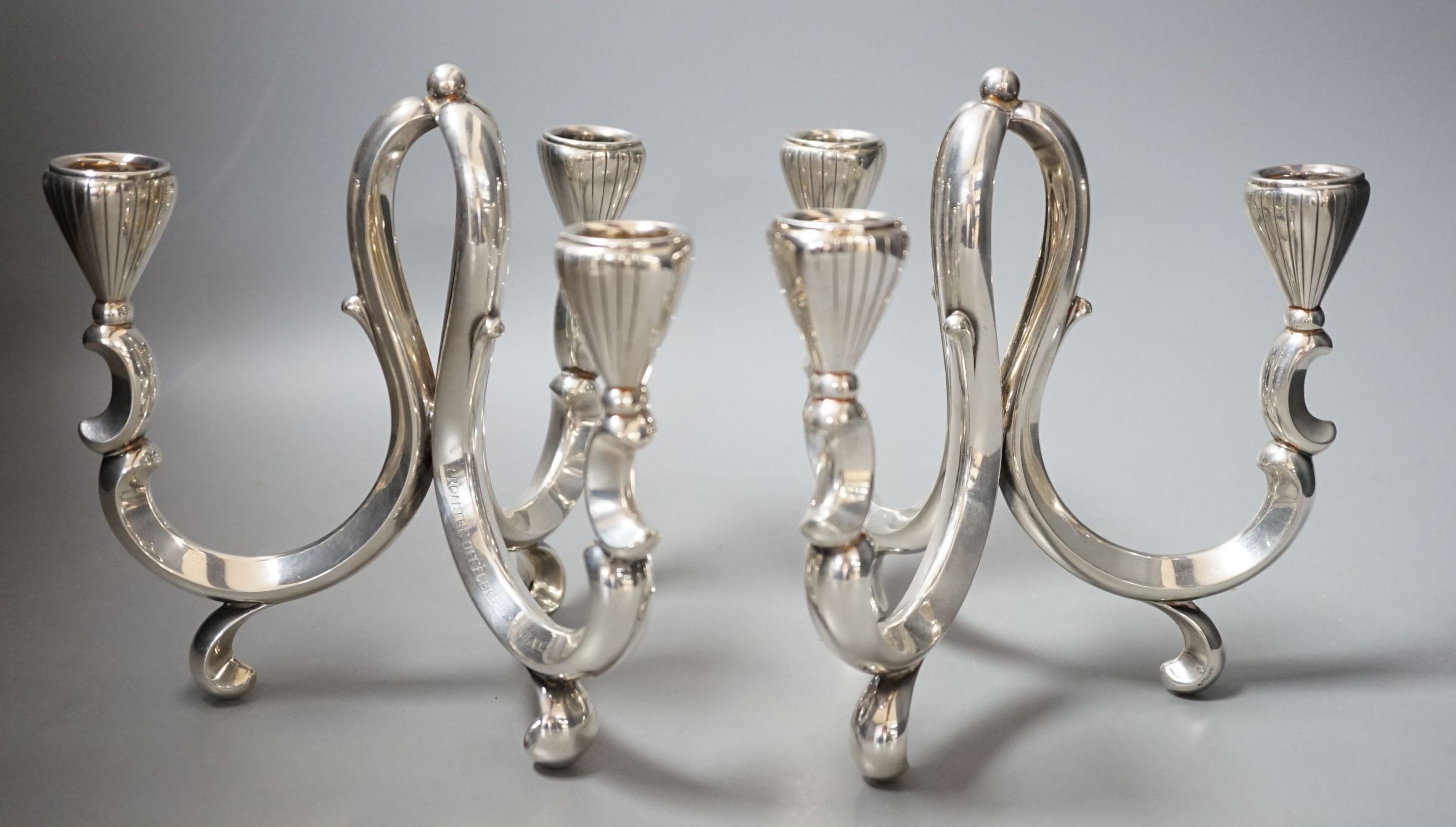 A pair of early 20th century German 835 white metal three light scroll arm candelabra, by Lutz & Weiss, height 18cm